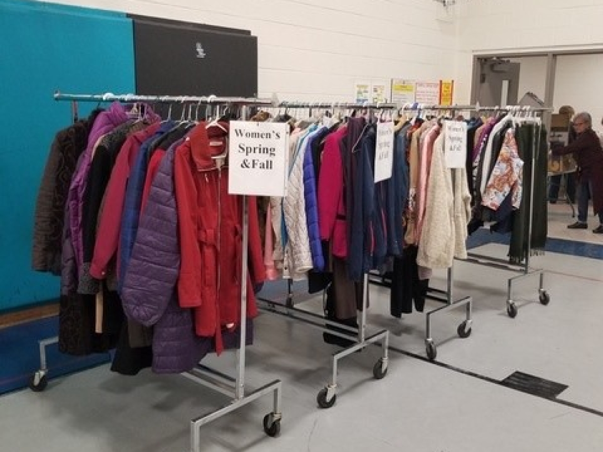 Coats on hangers and coat racks in a school gym
